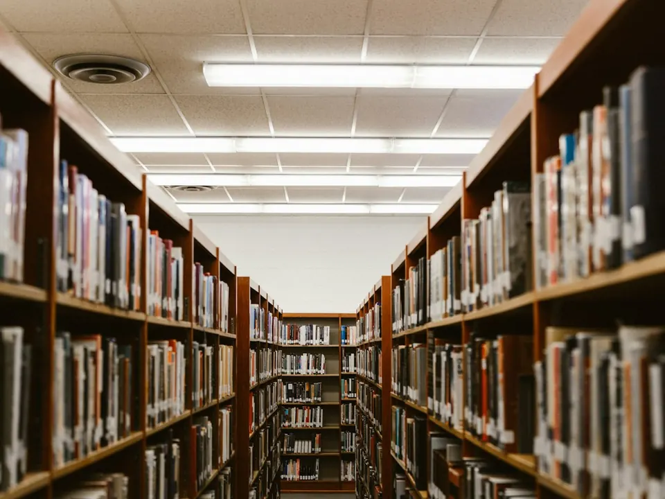Corredor entre estantes altas repletas de livros